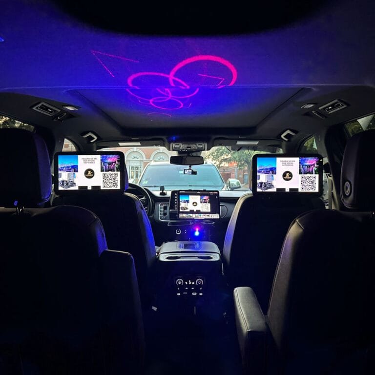 Rear entertainment screens and ambient lighting inside a luxury SUV