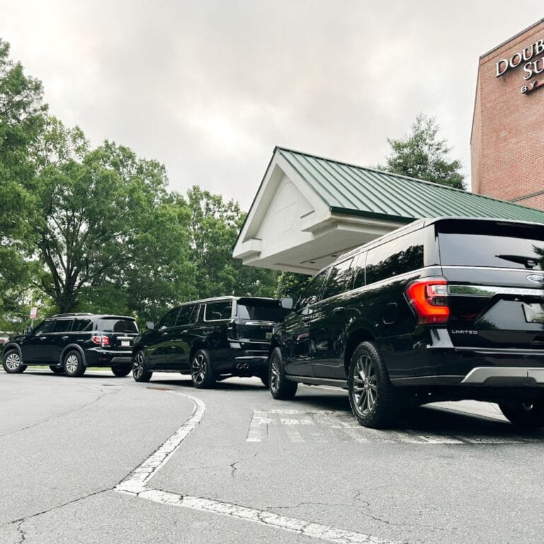 Black SUVs parked outside a Charlotte venue for an event transfer
