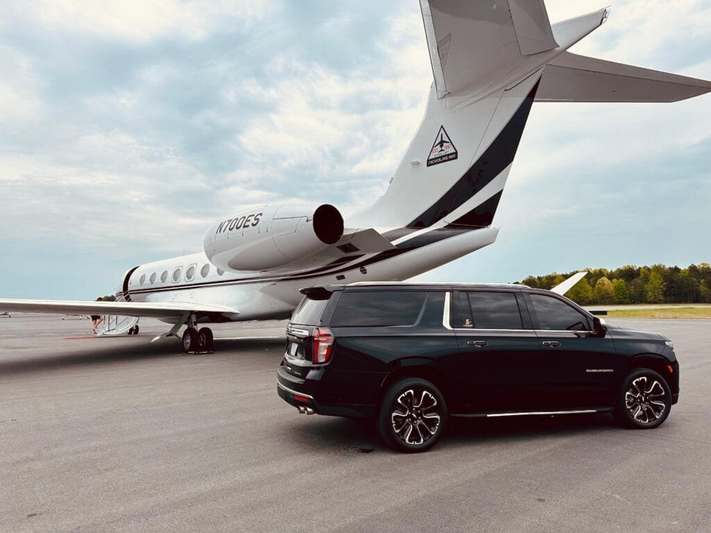 Black Chevrolet Suburban beside a private jet for an airport transfer in Charlotte
