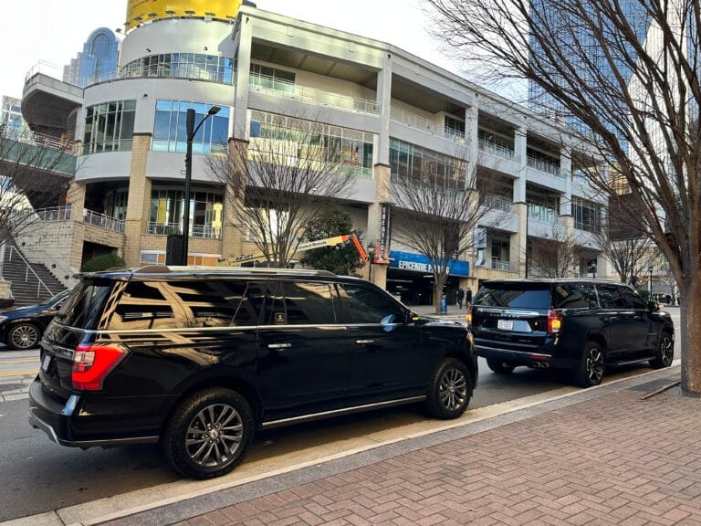 Black SUVs parked outside a building
