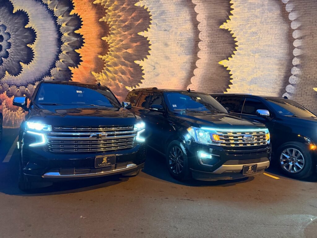 Two black SUVs with headlights on in Uptown Charlotte